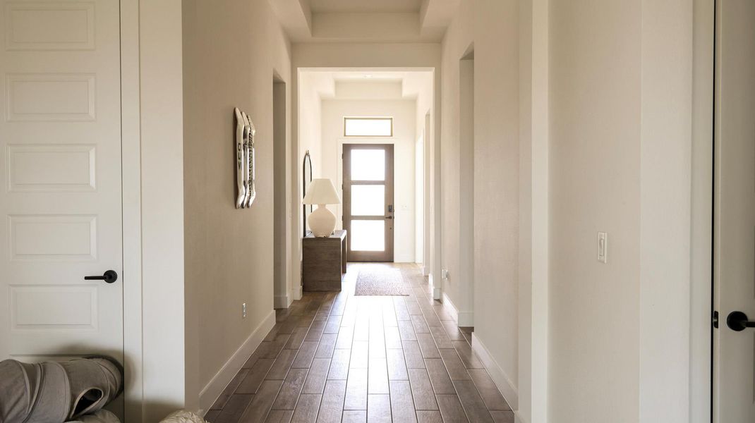 A graceful entry hall welcomes guests with tray ceilings and wood-look flooring. A graceful entry hall welcomes guests with tray ceilings and wood-look flooring.