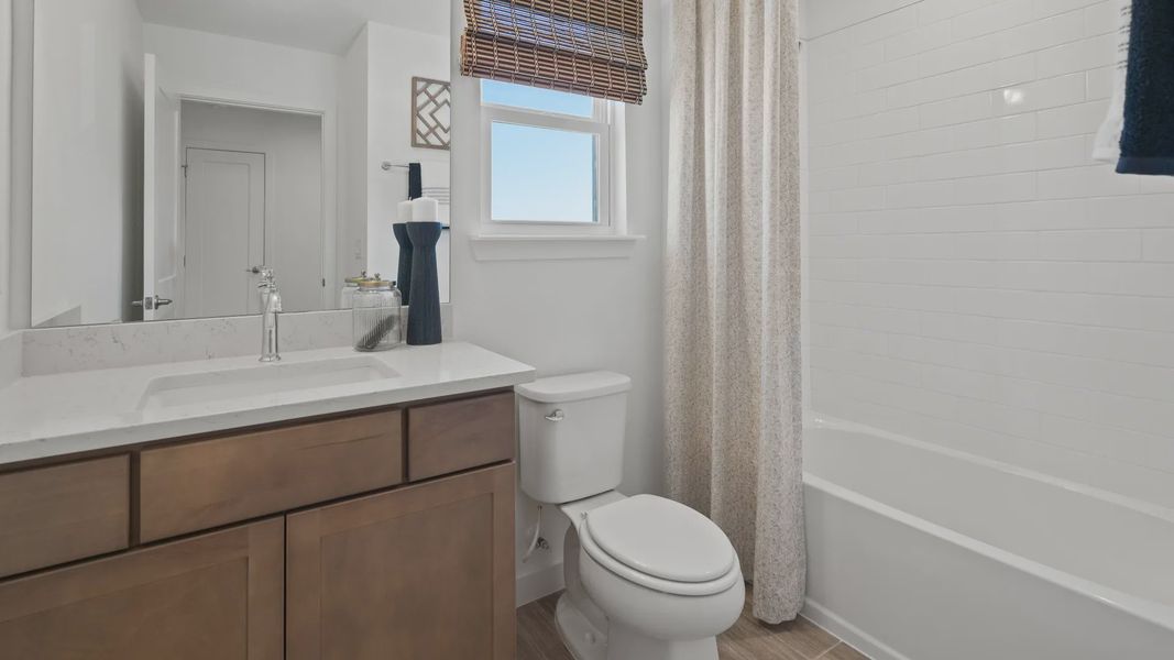 Full bath with window and shower/tub combo in a DRB Home Clementine model at the Trinity Place community.