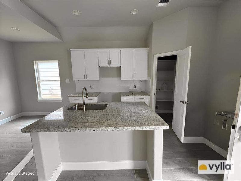 The kitchen offers ample granite counter space for easy meal preparation, as well as a breakfast island bar.