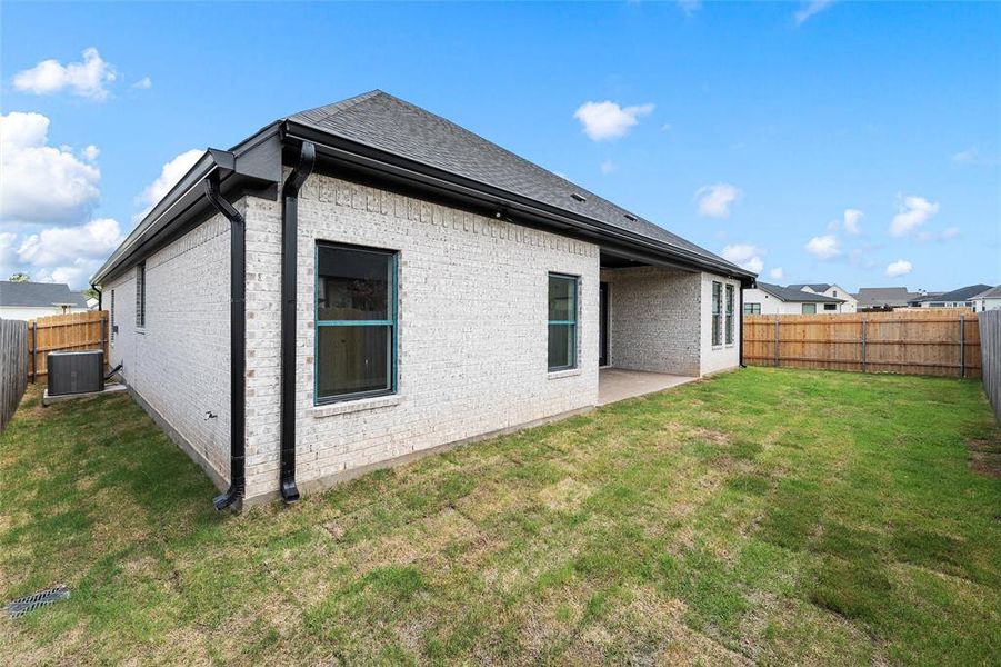 Rear view of property with a fenced backyard, a patio area, and brick siding Rear view of property with a fenced backyard, a patio area, and brick siding