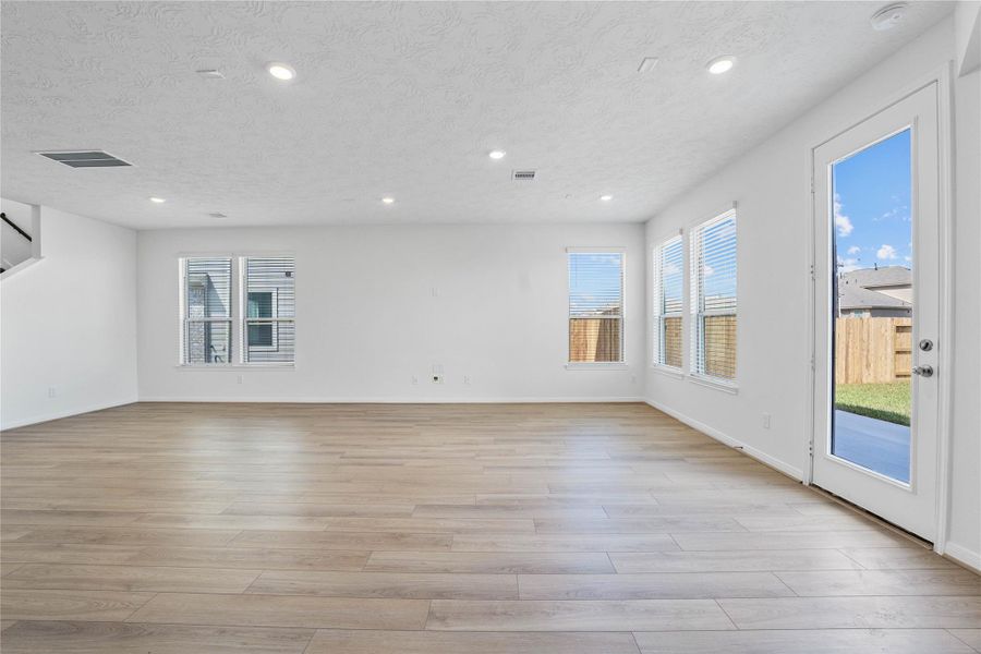 This bright and airy Great Room offers a spacious layout ideal for both relaxing evenings and lively gatherings. Designed for comfort and connection, it features vinyl plank flooring, large windows with blinds, high ceilings, recessed lighting, and seamless access to the stunning kitchen—perfect for everyday living and entertaining alike. This bright and airy Great Room offers a spacious layout ideal for both relaxing evenings and lively gatherings. Designed for comfort and connection, it features vinyl plank flooring, large windows with blinds, high ceilings, recessed lighting, and seamless access to the stunning kitchen—perfect for everyday living and entertaining alike.