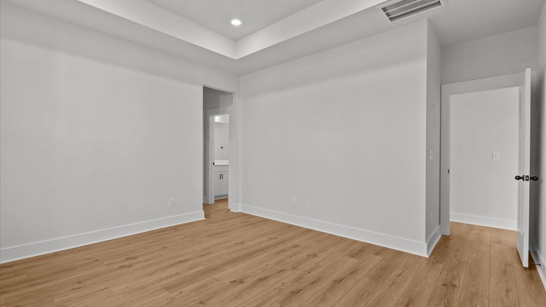 Superior design meets vibrant comfort in this primary suite with hardwood floors and walk-in closet Superior design meets vibrant comfort in this primary suite with hardwood floors and walk-in closet