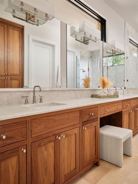 Luxurious double vanity with marble countertops and ample storage cabinetry. Luxurious double vanity with marble countertops and ample storage cabinetry.