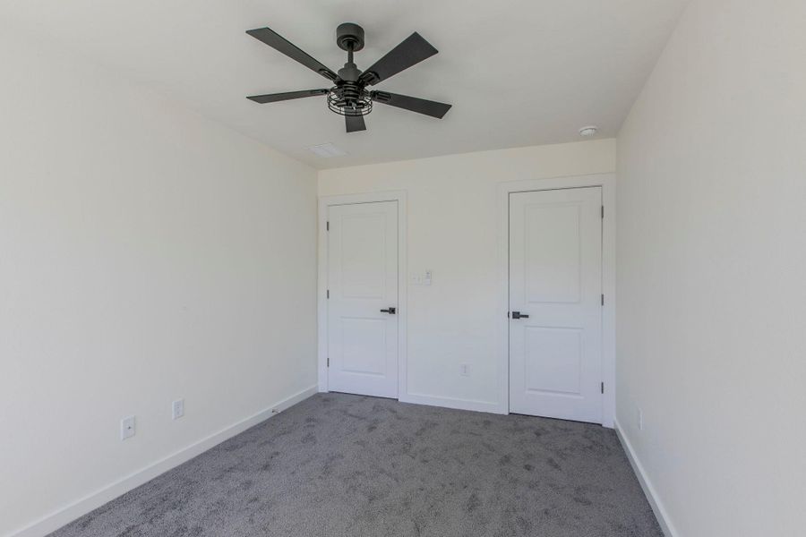 Unfurnished bedroom featuring carpet floors and ceiling fan