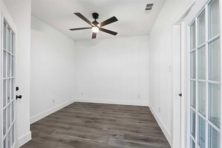 Unfurnished room featuring dark wood-style floors, french doors, and ceiling fan