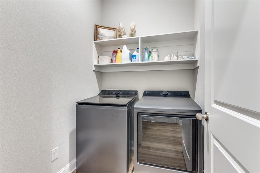 Laundry room with separate washer and dryer and a textured wall Laundry room with separate washer and dryer and a textured wall