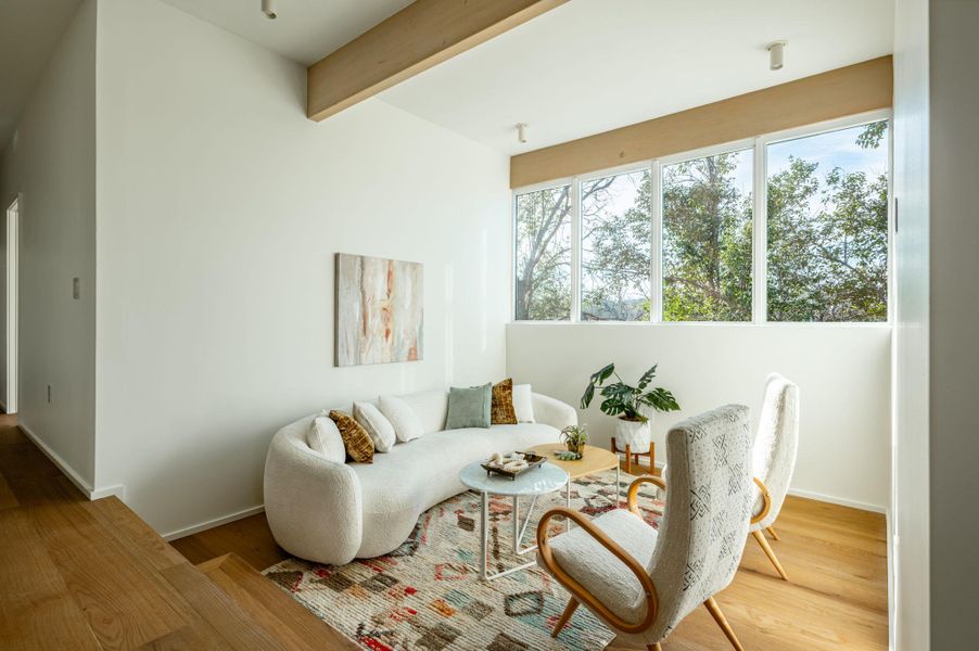 Living area with beam ceiling and wood finished floors
