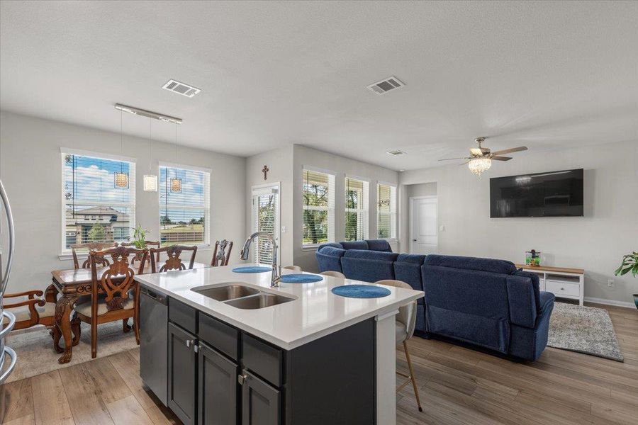 An open floor plan connects the kitchen island to a bright living area.