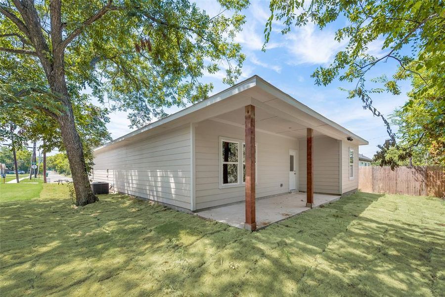 View of home's exterior featuring a lawn, central AC, and a patio area