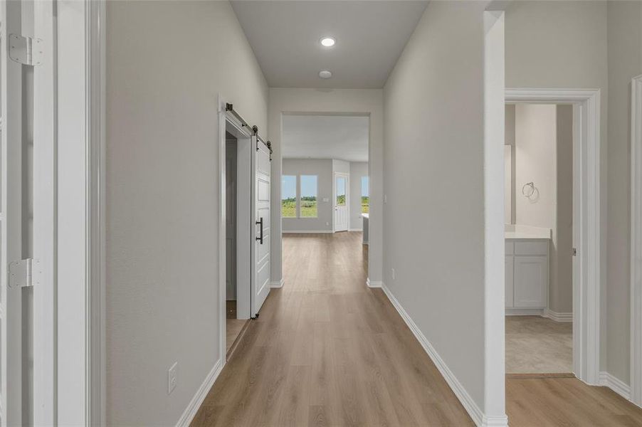 Inviting hallway with wood-finish flooring and recessed lighting Inviting hallway with wood-finish flooring and recessed lighting