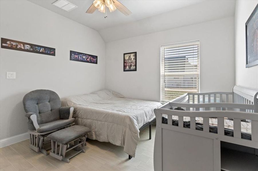 Bedroom with vaulted ceiling, visible vents, and baseboards