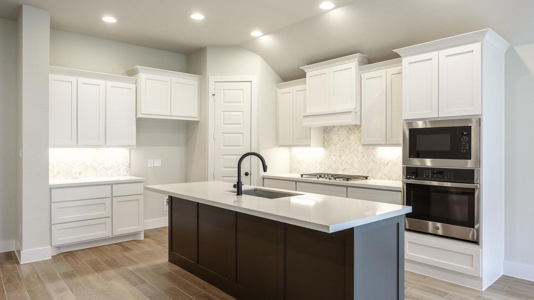 Kitchen with stainless steel appliances, a sink, recessed lighting, decorative backsplash, and light countertops Kitchen with stainless steel appliances, a sink, recessed lighting, decorative backsplash, and light countertops