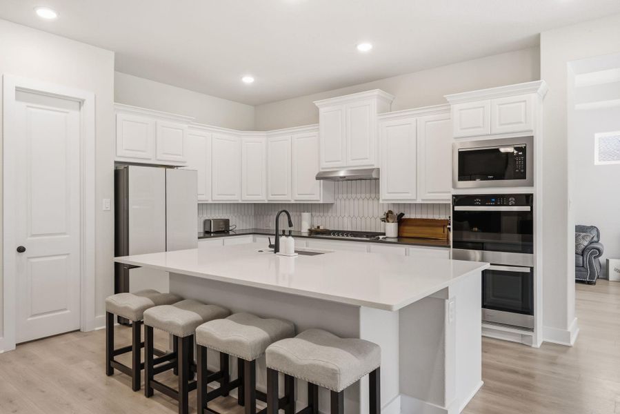 Premium stainless appliances, including a built-in gas cooktop and double ovens, make preparing holiday feasts or simple weeknight dinners feel completely effortless