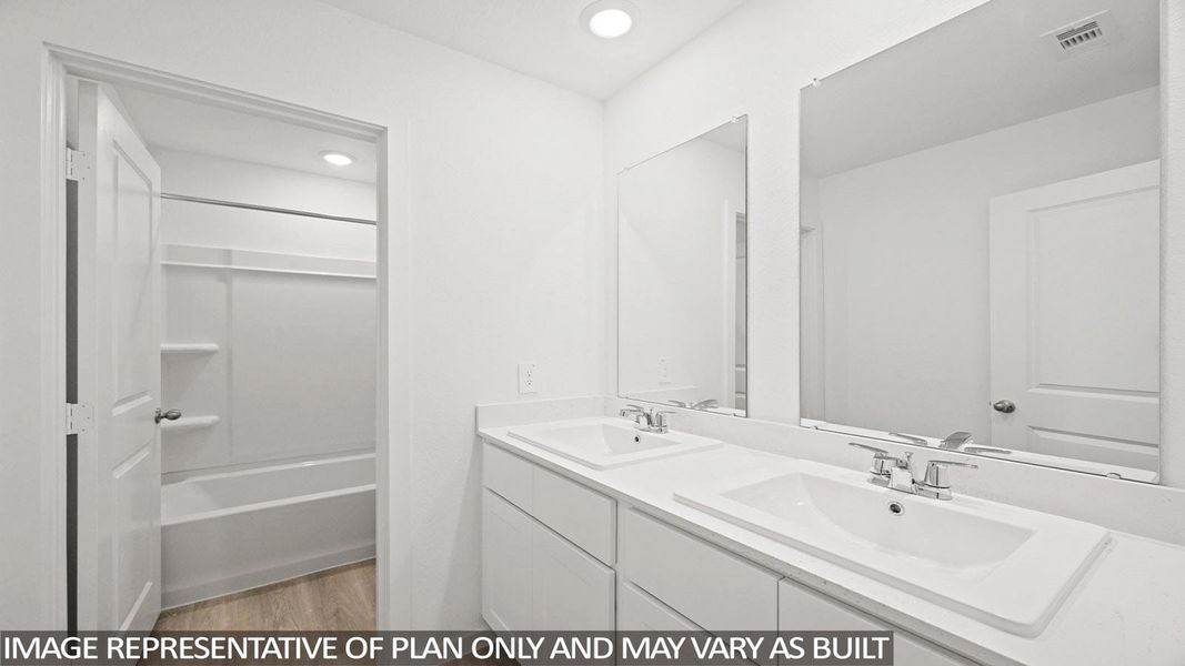 Full bathroom with double vanity, light wood-style floors, shower / bath combination, and recessed lighting