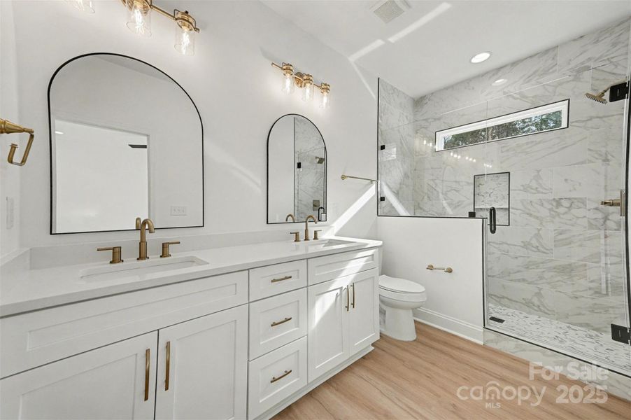 This shower offers a spa-like experience with its elegant tiling, clear glass enclosure, and the added benefit of a transom window, allowing ample natural light to flood the space. This shower offers a spa-like experience with its elegant tiling, clear glass enclosure, and the added benefit of a transom window, allowing ample natural light to flood the space.