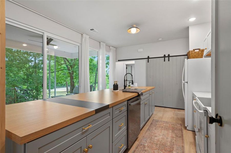 All of the natural light you need to meal prep or entertain at the 12-foot kitchen island entering through the wall of windows!