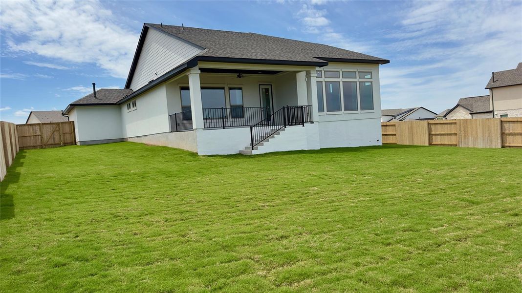 Rear view of house with a fenced backyard, ceiling fan, a patio area, stucco siding, and roof with shingles