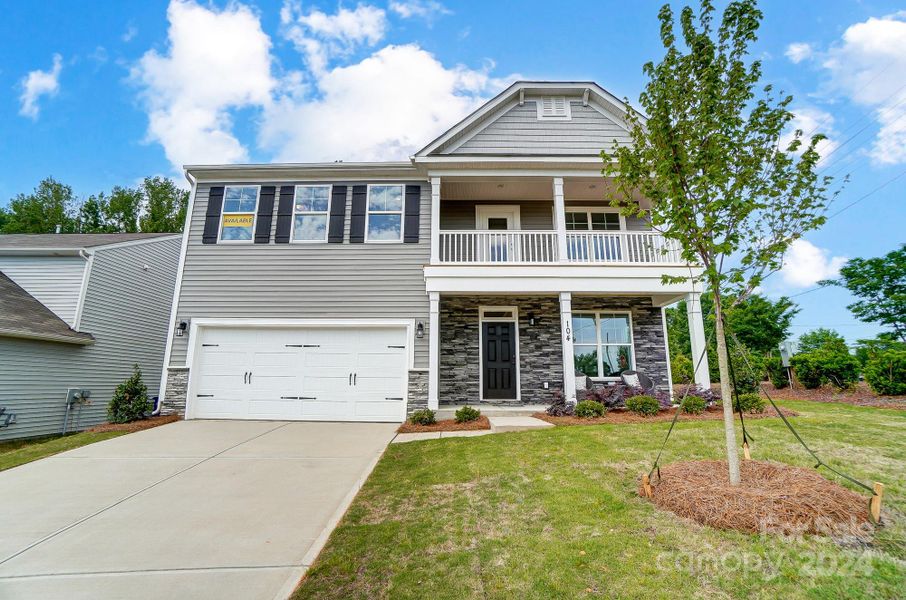 MOVE-IN READY! Homesite 1 features a Wilmington F floorplan with a second story porch and a front-load garage.