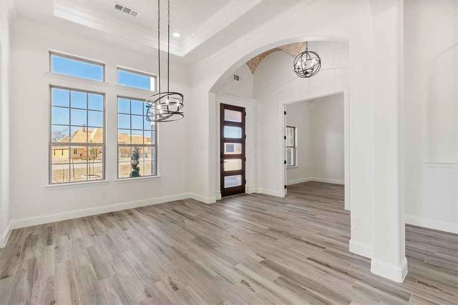 Entryway with ornamental molding, a groin entrance ceiling, an decorative flooring