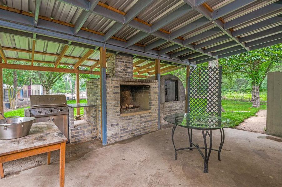 View of patio / terrace with grilling area and an outdoor brick fireplace
