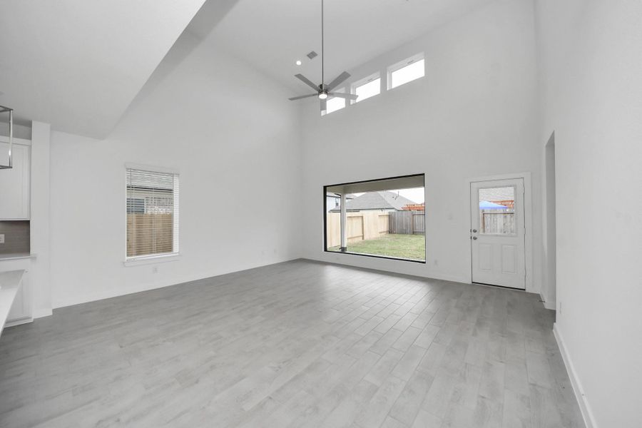 Gather the family and guests together in your lovely living room! Featuring soaring high ceilings, recessed lighting, ceiling fan, custom paint, gorgeous floors, and large windows that provide plenty of natural lighting throughout the day. Sample photo of completed home with similar floor plan. Actual colors and selections may vary. Gather the family and guests together in your lovely living room! Featuring soaring high ceilings, recessed lighting, ceiling fan, custom paint, gorgeous floors, and large windows that provide plenty of natural lighting throughout the day. Sample photo of completed home with similar floor plan. Actual colors and selections may vary.