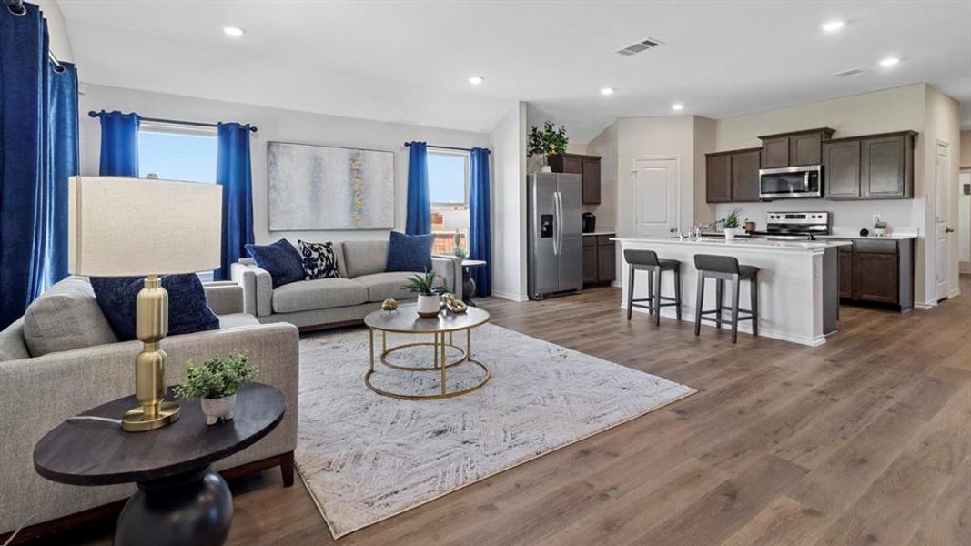 Living room featuring dark wood-style flooring, plenty of natural light, and recessed lighting