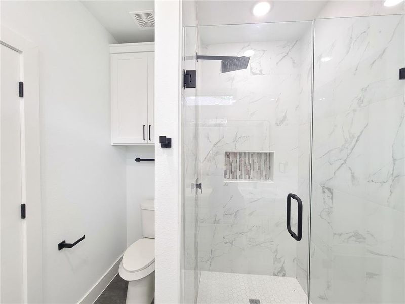 Full bath with a marble finish shower and toilet Full bath with a marble finish shower and toilet