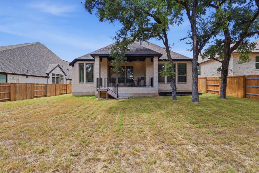A spacious backyard awaits, featuring a covered patio for outdoor entertaining and a private fenced yard.