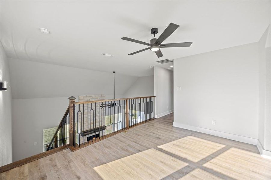 Spare room with ceiling fan, light wood-style flooring, and lofted ceiling