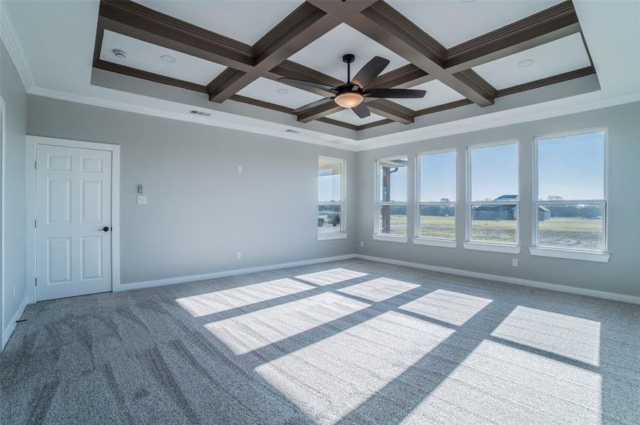 Carpeted empty room with ornamental molding, a ceiling fan, coffered ceiling, and beamed ceiling Carpeted empty room with ornamental molding, a ceiling fan, coffered ceiling, and beamed ceiling