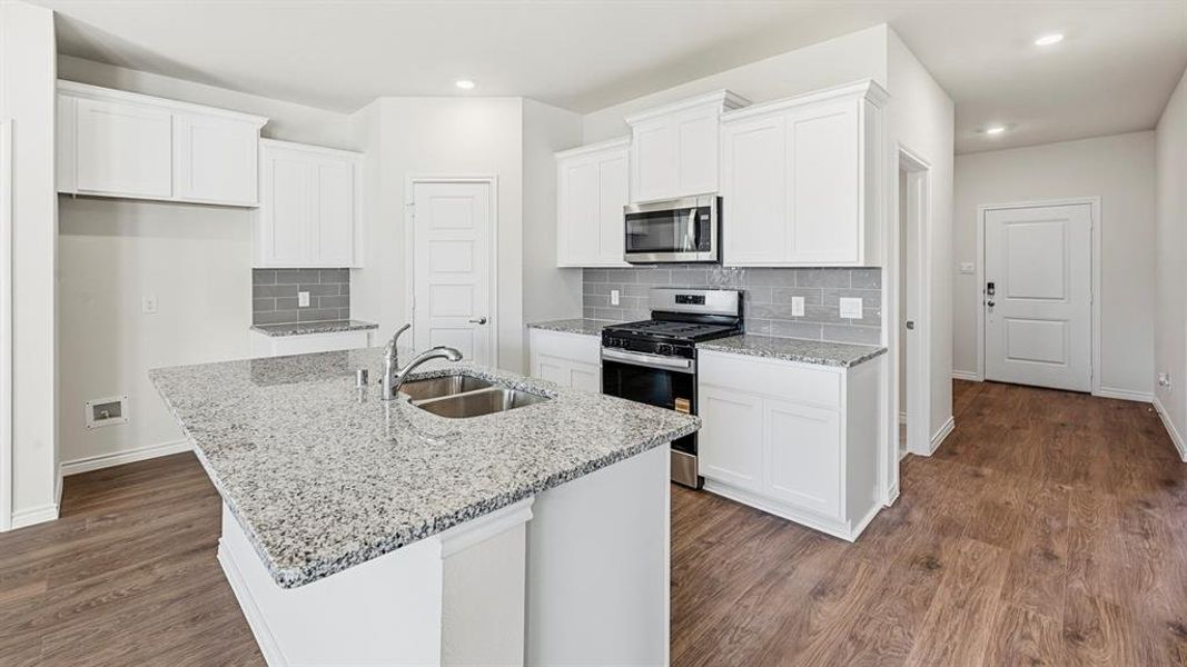 Kitchen with stainless steel appliances, white cabinetry, tasteful backsplash, dark wood finished floors, and recessed lighting Kitchen with stainless steel appliances, white cabinetry, tasteful backsplash, dark wood finished floors, and recessed lighting