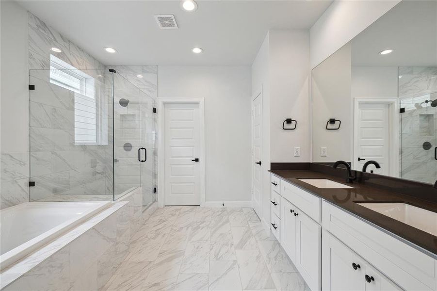 Elegantly designed primary bathroom featuring a spacious double vanity set against a backdrop of modern finishes. The contemporary design is visually appealing and highly functional.