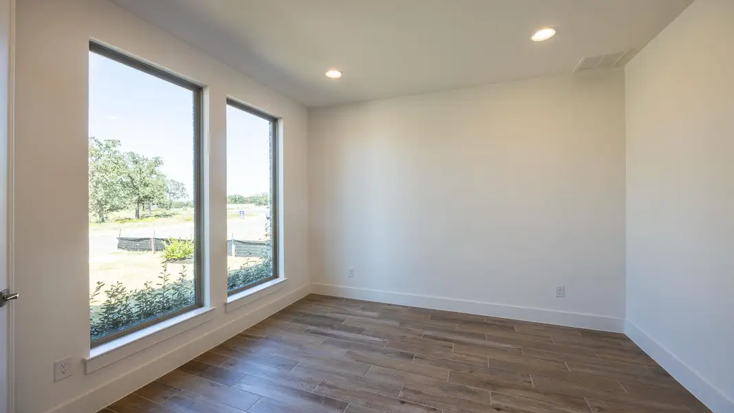 Empty room featuring recessed lighting and dark wood-style floors Empty room featuring recessed lighting and dark wood-style floors