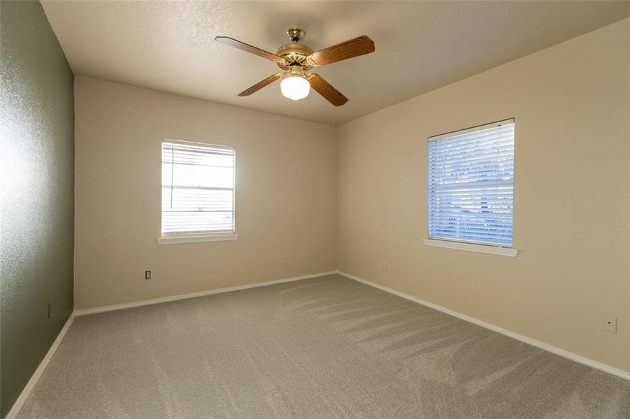 Spare room featuring light carpet and ceiling fan Spare room featuring light carpet and ceiling fan
