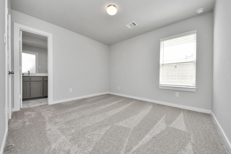 Secondary bedroom features plush carpeting, large windows that let in plenty of natural light, bright paint, and spacious closets.