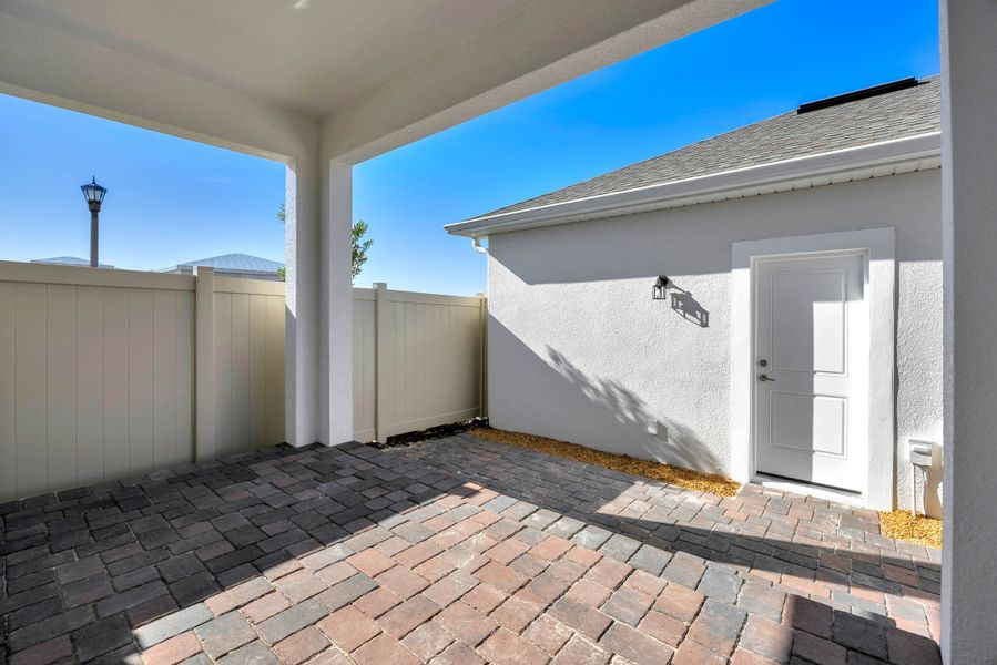 Exterior details and patio area of a home in Harvest at Ovation - Townhomes, Winter Garden (Image 17).