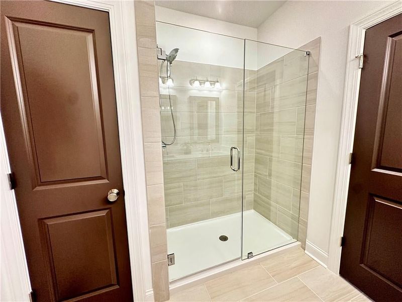 Owners bathroom with frameless Shower with upgraded tiles and linen closet *Photos shown are from same floor plan, but different staged home*