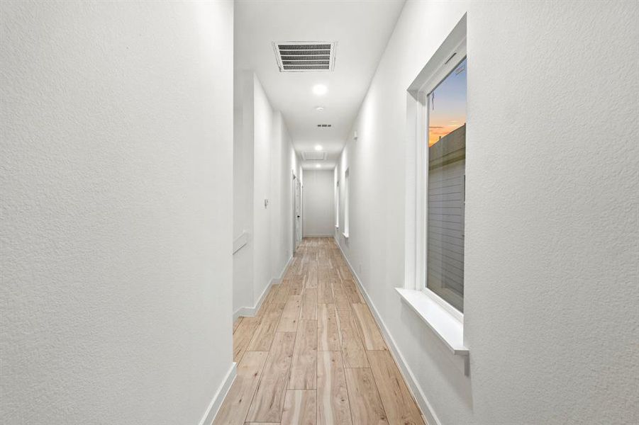 Hall with light wood-style flooring, baseboards, and recessed lighting Hall with light wood-style flooring, baseboards, and recessed lighting