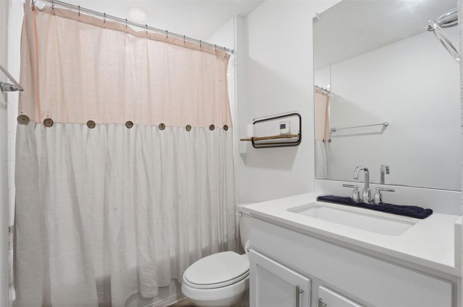 Bathroom featuring a white vanity with a rectangular undermount sink, a chrome-finish faucet, and an expansive wall-mounted mirror