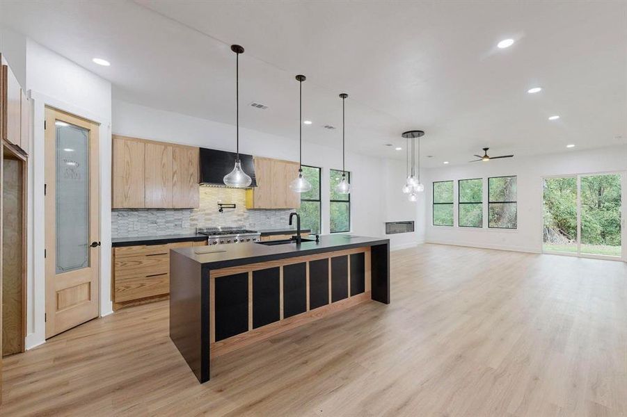 Open-concept living space with wood-finish flooring Open-concept living space with wood-finish flooring