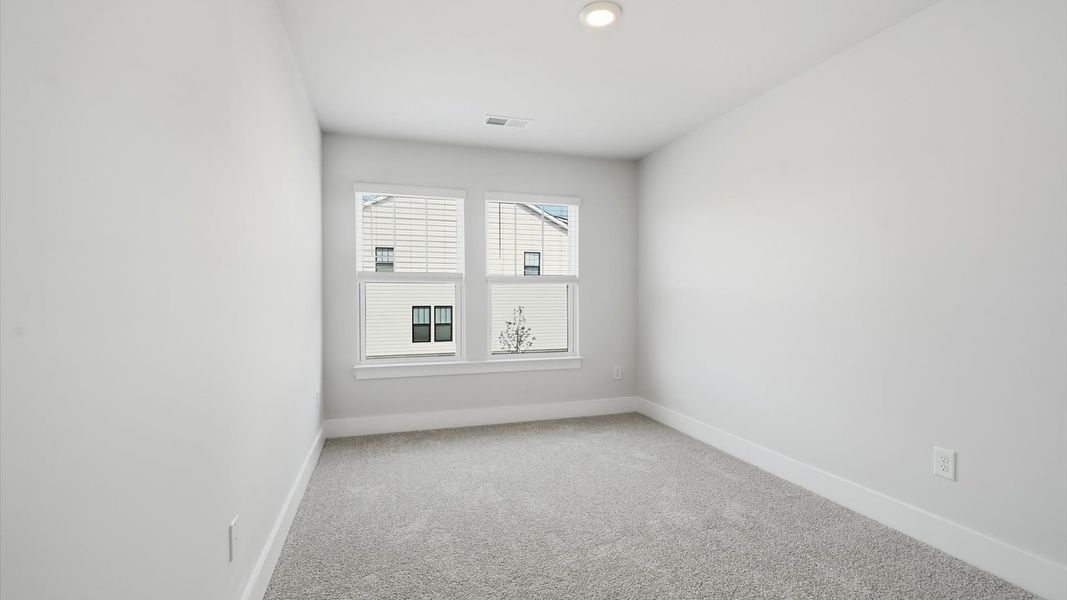 Tasteful bedroom with plush carpet, a walk-in closet, and large windows for abundant natural light at Gresham Station