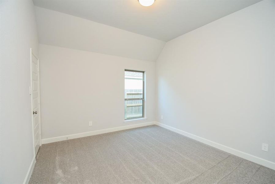 Inviting Second Bedroom: Bright, cozy space with plush carpeting and a generous window offering natural light.