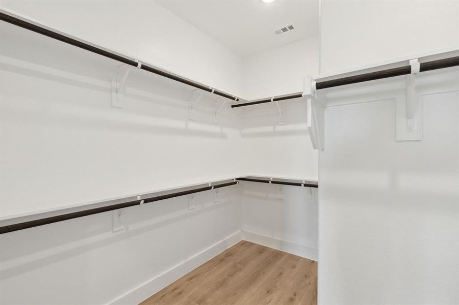 Spacious closet featuring light hardwood / wood-style flooring