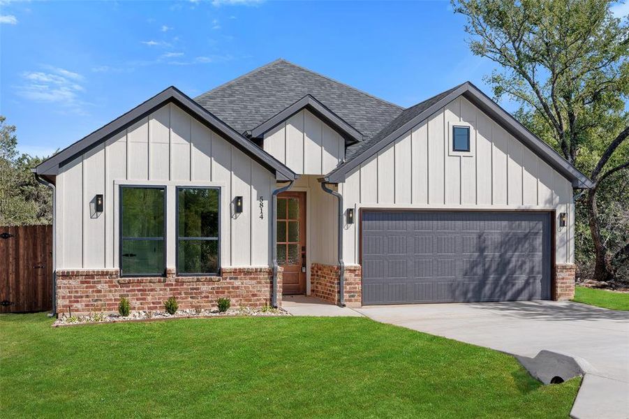 Modern inspired farmhouse with a front lawn and a garage