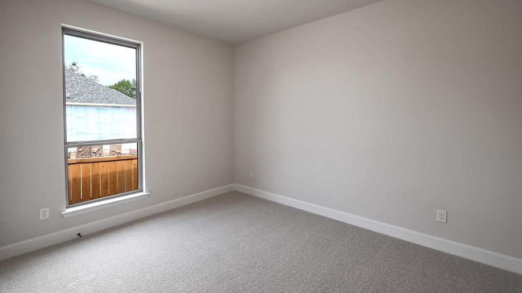 Carpeted empty room featuring baseboards