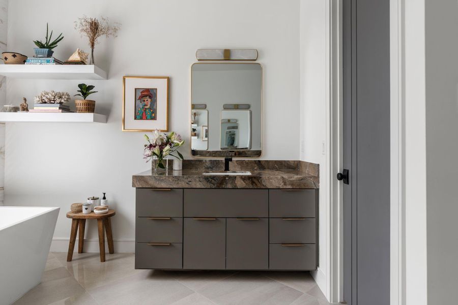 The secondary vanity adds even more everyday convenience with stone countertops, sleek cabinetry and floating shelves.