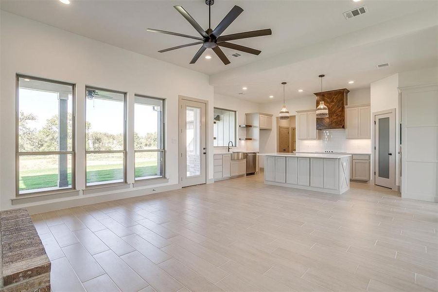 Unfurnished living room featuring light hardwood / wood-style flooring, sink, and ceiling fan