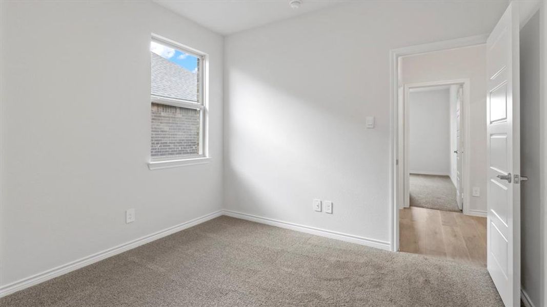 Spare room featuring light colored carpet and baseboards
