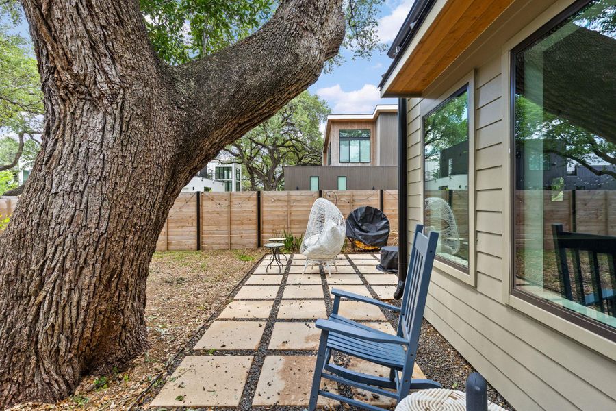 Mature trees and a tiled patio offer a serene outdoor retreat beside this modern residence. Mature trees and a tiled patio offer a serene outdoor retreat beside this modern residence.