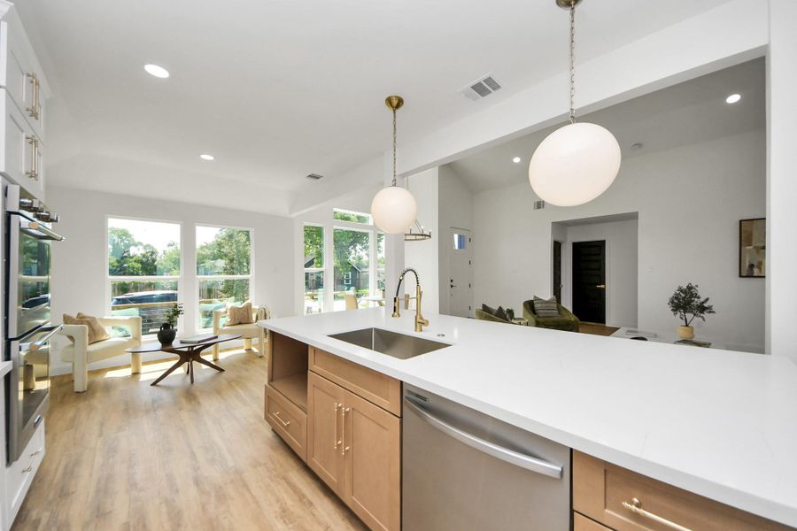 A beautifully curated kitchen where modern white cabinetry with glass accents meets warm brass hardware and soft, ambient lighting. The sleek induction cooktop and stainless steel range hood offer a streamlined look, while a beige subway tile backsplash brings just the right touch of warmth and texture. A beautifully curated kitchen where modern white cabinetry with glass accents meets warm brass hardware and soft, ambient lighting. The sleek induction cooktop and stainless steel range hood offer a streamlined look, while a beige subway tile backsplash brings just the right touch of warmth and texture.